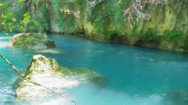 Dağ nehri kanyonu kristal berrak mavi suyla.