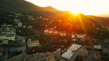 İnsansız hava aracı manzarası, güneş, güneş ışınlarıyla güzel bir gün batımında dağ manzarasının arkasında batar..