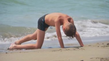 Bir çocuk kumsalda kumsalda oynuyor..