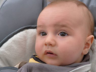 Bebek arabasında oturan bir bebeğin yakın plan portresi..