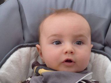 Bebek arabasında oturan bir bebeğin yakın plan portresi..