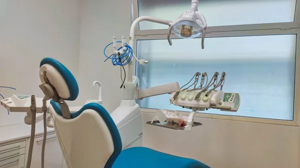 Modern dental office. Dental chair and other accessories used by dentists in blue, medical light.
