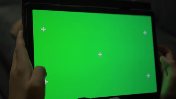 緑色のクロマのキー スクリーンが付いているタブレット コンピュータを握っている男の手の近くのショット ビデオを見たり カフェでオンラインチャットをしたりする男 常にオンライン4Kテンプレートの映像 — ストック動画