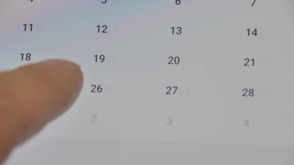 スマートフォンのクローズアップ 適切な日付を探しているカレンダーを指スクロールします ミーティングまたは予約を確認する — ストック動画