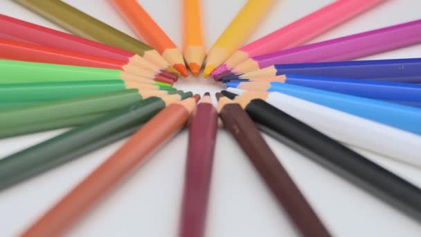 多彩な鉛筆が白い背景に横たわっています 明るい色の鉛筆が自ら回転する — ストック動画