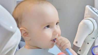 Bir bebek plastik kaşıkla oynar..