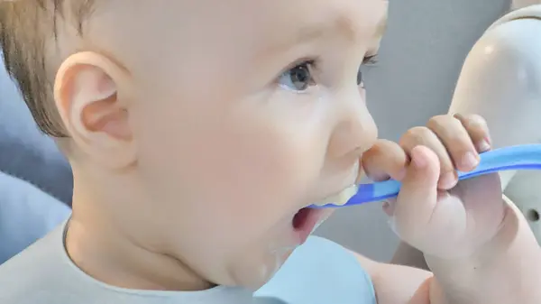 a baby plays with a plastic spoon.