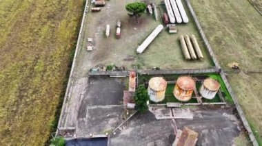 Petrol ve gaz depolama tanklarının hava görüntüsü, karadaki petrokimyasallar. Terk edilmiş çiftlik petrol sahası. Petrol ve gaz endüstrisi. Fosil yakıt enerji konsepti. İHA, 4K