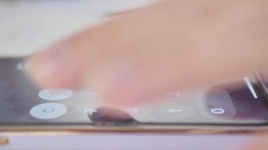 Telefon hesap makinesi. Genç bir adam hesap makinesi uygulaması kullanıyor..