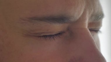 Bir erkeğin yüzüne yakın çekim. Güzel mavi, yeşil, gri gözlü beyaz bir erkek modeli. Aşırı yakın çekim makro fotoğraf, 4K