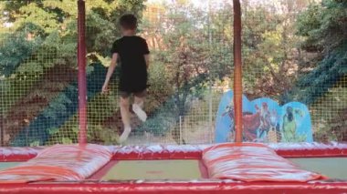 Roma, İtalya - 14 Temmuz 2023. Mutlu bir çocuk alışveriş merkezinde trambolinde zıplıyor. Spor merkezinde trambolinde zıplayan sağlıklı küçük çocuk..