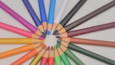 Renkli kalemler güneş ışınlarının arka planı gibi döner. Çizim için gökkuşağı kalemleri. Renkli kalem çeşitleri var. Okul konseptine dönelim..