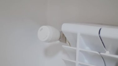 Radyatörü aç, erkek elleri ısıtıcıyı aç ve kapat, ısıyı elle aç, radyatörün termostatını aç, enerji tasarrufu yap, ısıyı evde ısıt. Konsept: