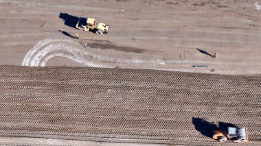 Toprak taşıma ekipmanları. Toprak hareket eden birkaç makineli büyük bir inşaat alanının havadan görüntüsü