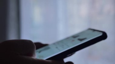 Elinde telefon olan, internetten alışveriş yapan bir adamın yakın plan fotoğrafı.