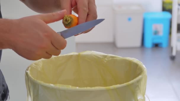 껍질을 요리사는 쓰레기통에 당근을 청소합니다 — 비디오