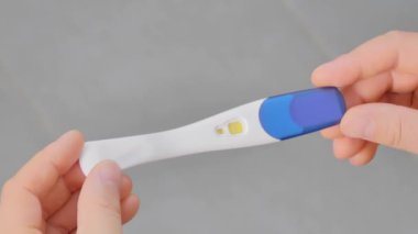 Hamilelik testi tutan erkek ellerinin yakın çekimi..