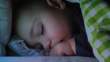 Küçük çocuk geceleri bir karyolada uyuyor..