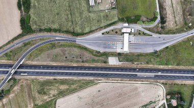 Paralı yoldan geçen bir arabanın kuş bakışı görüntüsü.