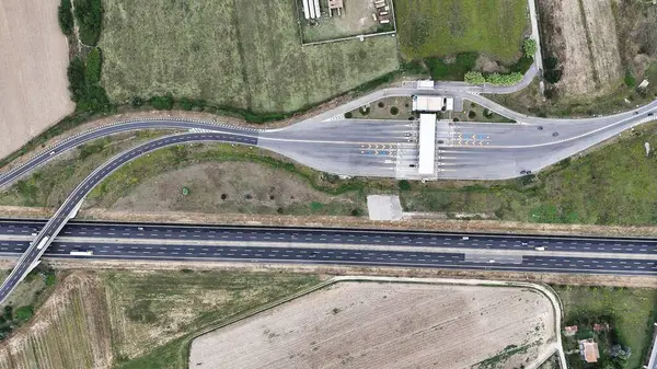 Birds-eye view of a car passing a toll road.