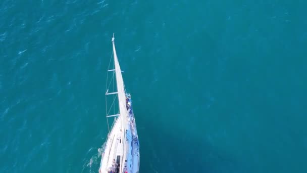 一艘小帆船正航行在广阔的开阔海洋中 四周全是水 船在波浪中滑行时 帆在风中飘扬 — 图库视频影像