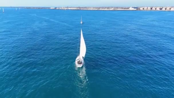 一艘小帆船正航行在广阔的开阔海洋中 四周全是水 船在波浪中滑行时 帆在风中飘扬 — 图库视频影像