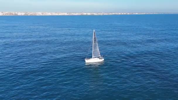 Solitary Sailboat Cruising Tranquil Blue Sea Coastal City — Stock video