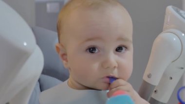 Yüksek sandalyede bir çocuğu besleyen bir annenin videosu..