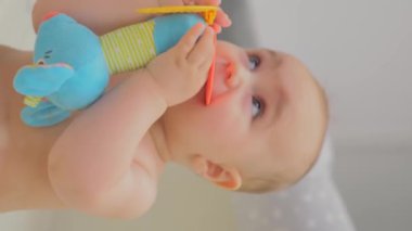 Renkli oyuncaklarla güneşli, rahat bir odada Meraklı Bebek Oyun Zamanı.