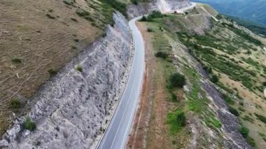 Güzel, dolambaçlı bir yol yılanı verimli, dağlık arazide, insan mühendisliği ve doğa ihtişamı arasındaki hassas dengeyi gözler önüne seriyor. Gökyüzü berrak yeşillikleri büyütüyor ve...