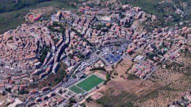 Yamaçtaki küçük bir İtalyan kasabasında kameralar, büyüleyici mimariyi ve çevresindeki manzarayı gösteriyor.