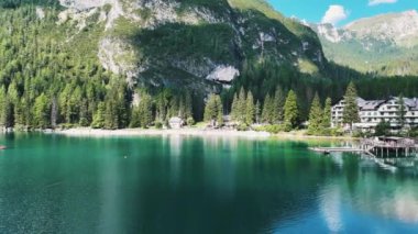 Braies Gölü insansız hava aracından, insanlar teknelerle seyahat ediyor..