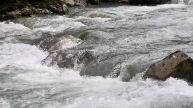 Flowing river water navigating around rocks in a dynamic current