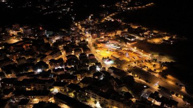 Geceleri ışıklar parlayan küçük bir kasabanın havadan görünüşü.