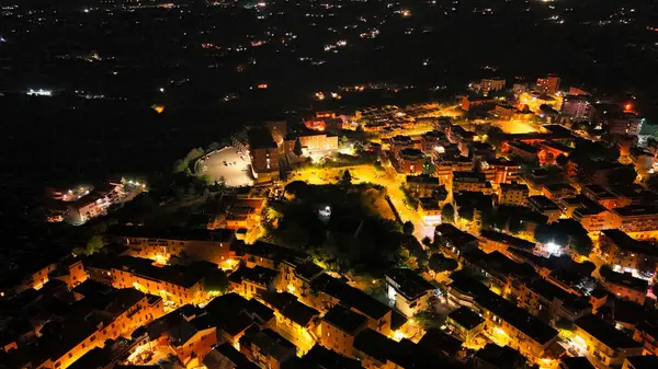 Karanlık doğayı kapladıkça, bir tepe kasabası sıcak altın ışıklarla canlanıyor, dolambaçlı caddelerden oluşan bir labirent ve yıldızlı bir gökyüzünün altındaki rahat evleri ortaya çıkarıyor, huzuru davet ediyor..