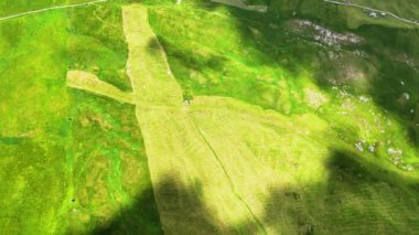 Bulut gölgesi hızla yeşil tepelerin üzerinden geçiyor. Evleri ve Alp dağlarında bir yolu var.