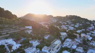 Parlak güneş ışığı, büyüleyici beyaz evleri ve yemyeşil yeşillikleri gözler önüne sererek, alacakaranlıkta huzurlu bir atmosfer yaratıyor..