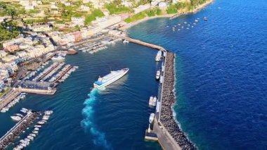 Renkli binalarla dolu hareketli bir limanda turkuaz sularda sallanan tekneler sergileniyor. Kıyı şeridi parlak öğle güneşinin altında bereketli bir manzarayı gözler önüne seriyor, keşifleri davet ediyor..