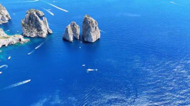 Capri 'deki yüksek uçurumların etrafını saran engin mavi sular, teknelerin sakin deniz manzarasında zarifçe dolaştıkları yerler. Güneş, canlı manzaraya sıcak bir ışıltı saçar. Keşif ve maceraya davetiye çıkarır..