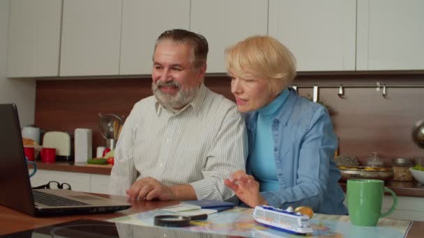 兴奋的退休老年夫妇在网上用笔记本电脑与家人分享视频通话 愉快地在室内展示护照和海上旅行机票 — 图库视频影像