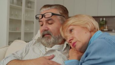 Endişeli, sevecen, olgun bir kadının portresi. Koroner kalp hastalığından muzdarip yaşlı bir adamı kucaklıyor ve teselli ediyor. İçeride destek, bakım ve empati gösteriyor..