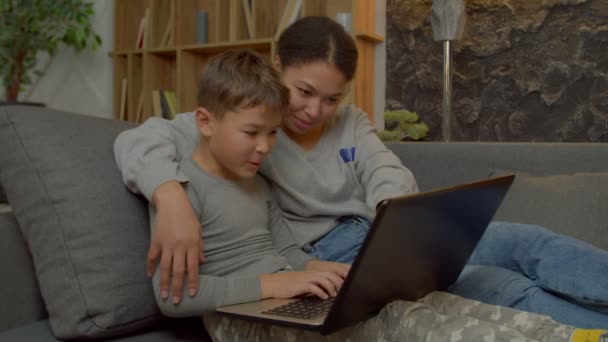 Pozitív Imádnivaló Többnemzetiségű Iskolás Fiú Kanapén Online Dolgozik Laptop Megvitatása — Stock videók