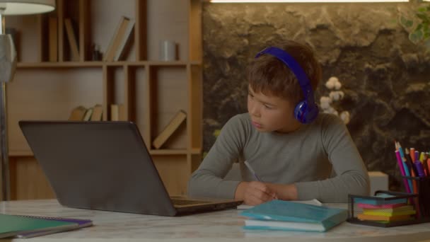 Roztomilý Koncentrovaný Multiraciální Předdospívající Chlapec Bezdrátových Sluchátkách Learning Pomocí Notebooku — Stock video