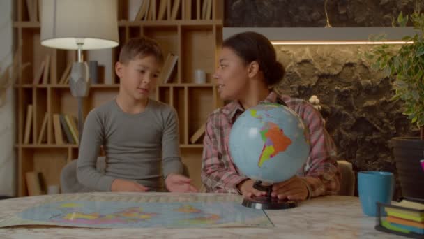 有爱心的有吸引力的非洲裔美国母亲教可爱的多族裔学龄儿童地理课 带着世界地图 一边学习大陆和海洋 一边在自家的房间里学习 — 图库视频影像