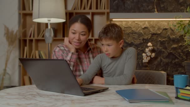 사랑스럽게 사춘기 이전의 애정어린 매력적 아시아 어머니 노트북 사용하여 온라인으로 — 비디오