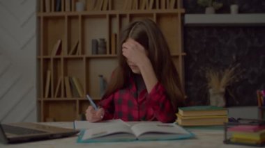 Tatlı, sinir bozucu Latin kız okul ödevini egzersiz kitabına yazıyor ve eğitim materyallerini anlamakta sorun yaşıyor. Evde öğrenirken öfke ve hayal kırıklığını dile getiriyor..