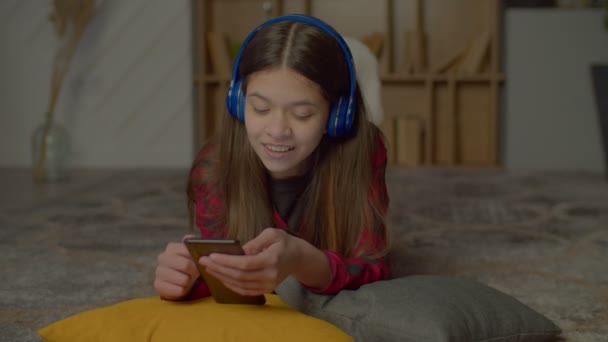 Portrét Pozitivní Okouzlující Latinské Teenager Dívka Bezdrátových Sluchátkách Ležící Podlaze — Stock video