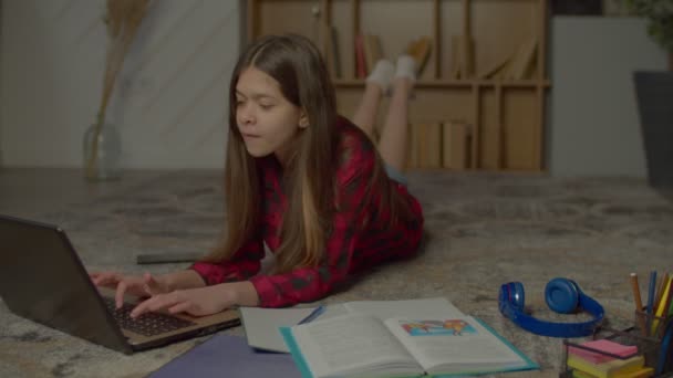 在室内躺下的时候 用笔记本电脑和课本学习 准备中学作业 并在练习本上写作业 这对聪明的西班牙少女很有帮助 — 图库视频影像