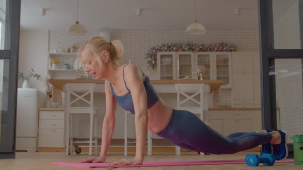 Aktiv Ermittelte Sportlich Fitte Seniorin Übt Yoga Seitenplankenposition Auf Fitnessmatte — Stockvideo