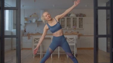 Aktif, çekici spor spor fitness son sınıf öğrencisi, yoga pozisyonunda esneme, kasık ve dizlerini güçlendirme ve uzatma egzersizleri yapıyor..